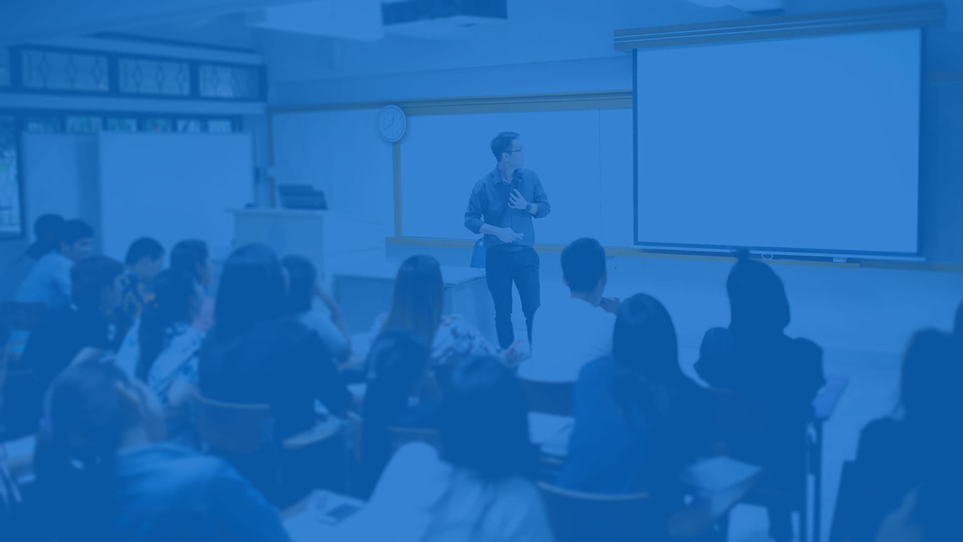 A professor standing in front of students in a classroom